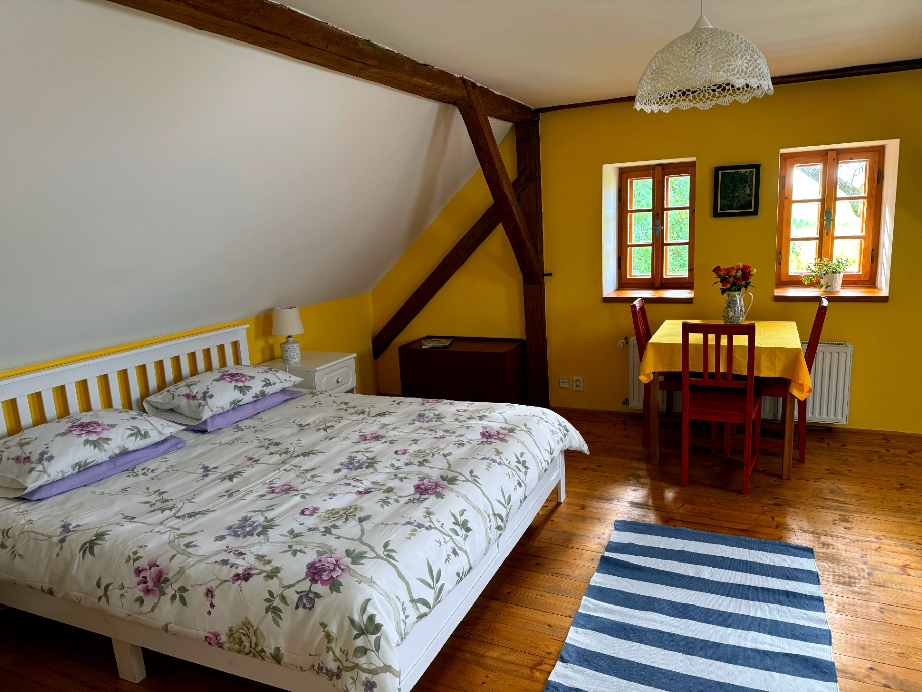 Apartmán č. 10 — ložnice se žlutou postelí a trámy