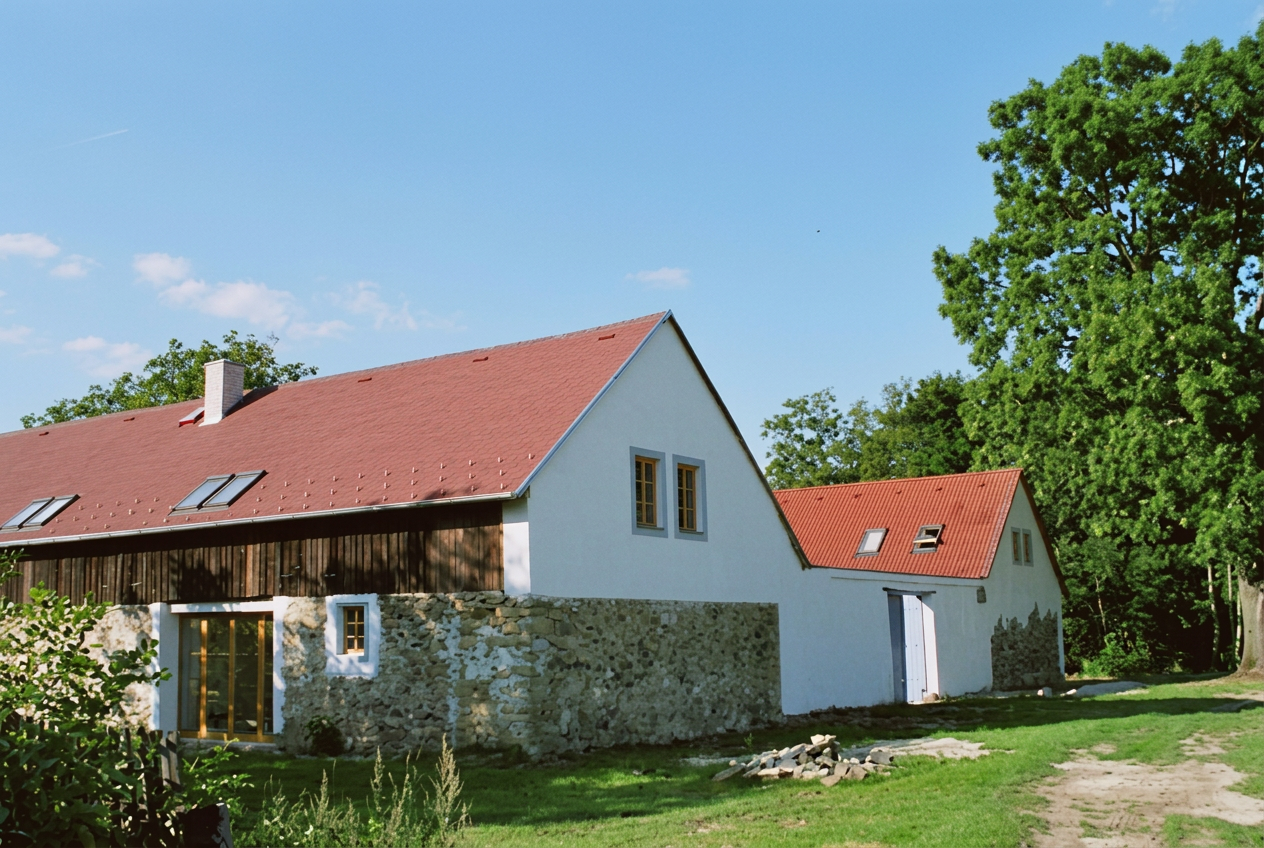 Hlavní stavení s kamennou stěnou a červenou střechou